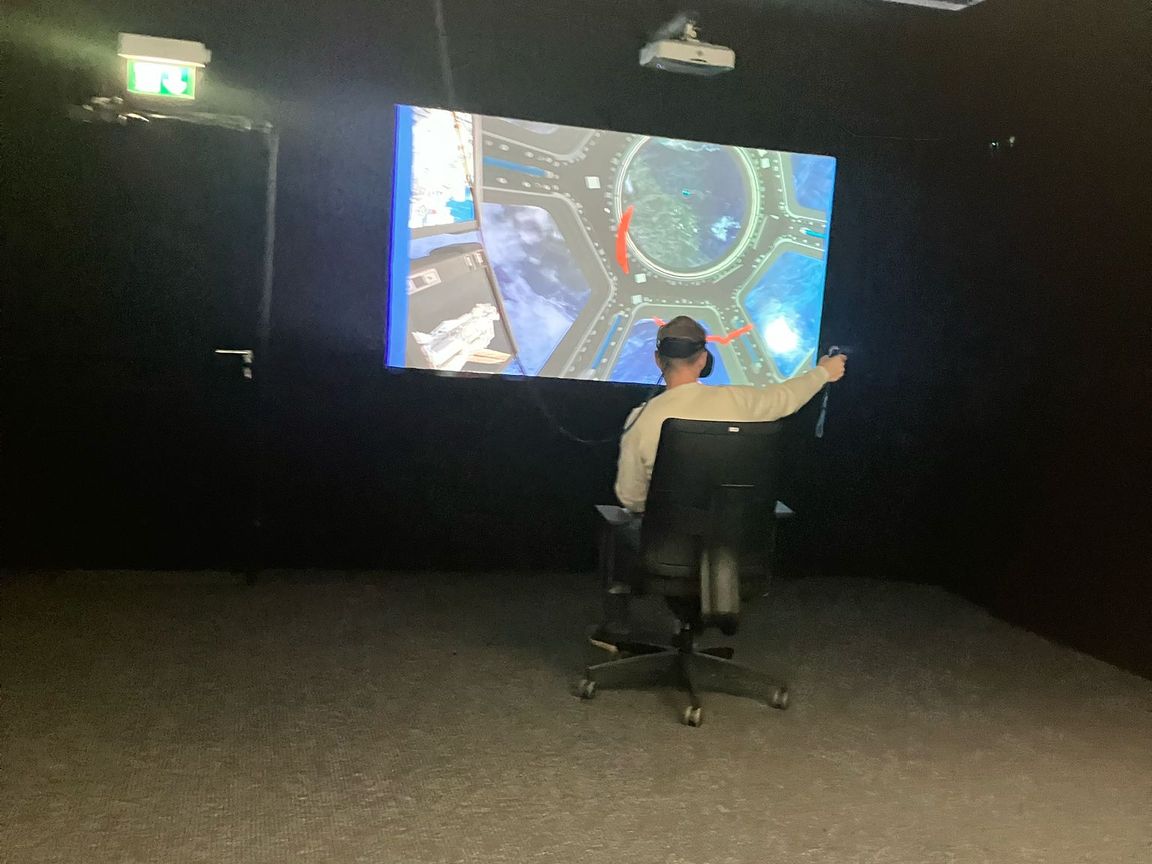 Me sitting in a chair with a VR headset on, moving in a simulated ISS